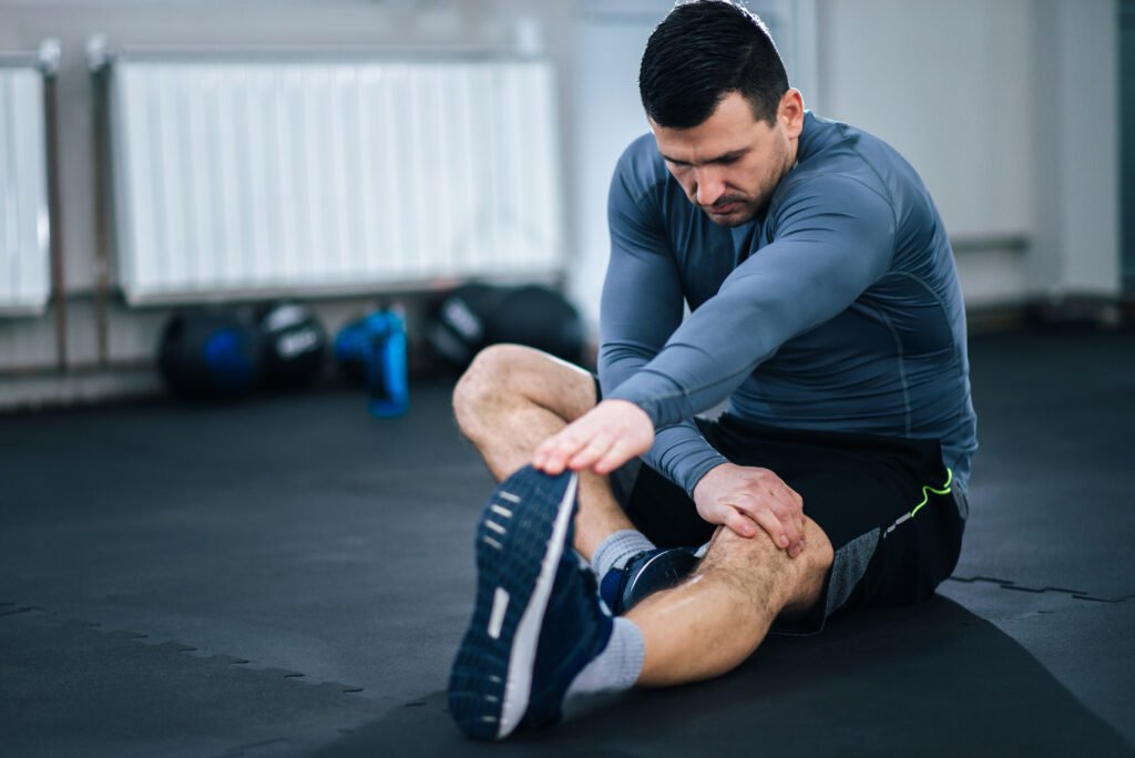 Muscular Man Stretching His Legs Before Workout.